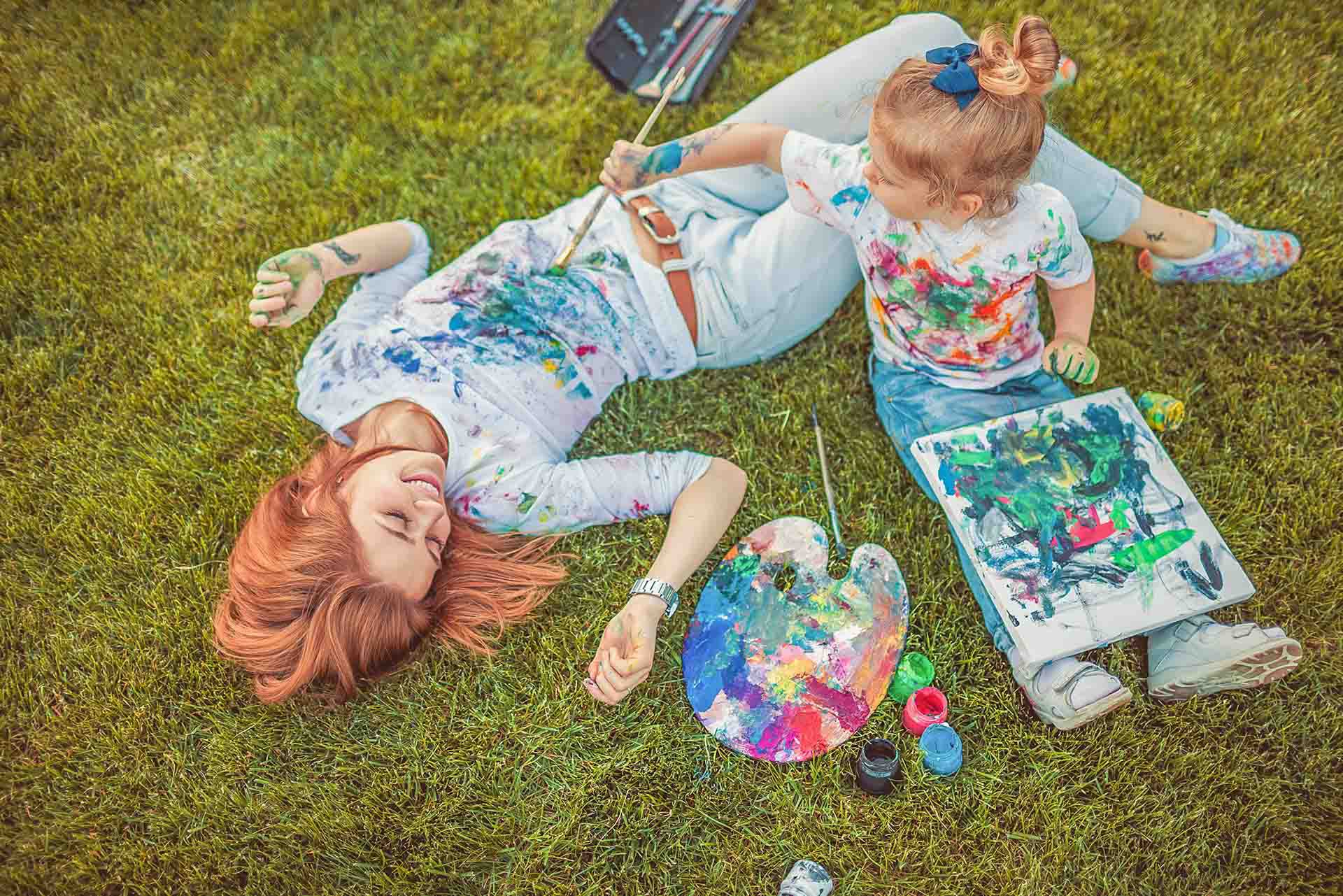 Bebé jugando con pintura con su mamá