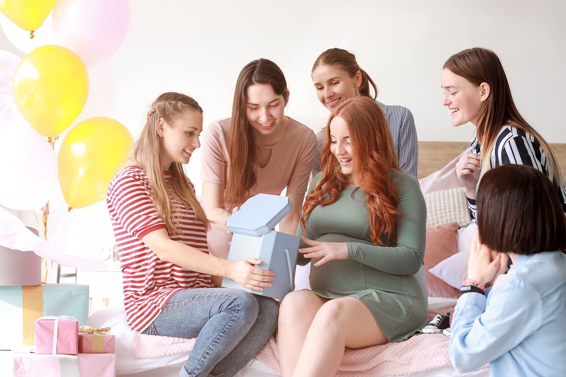 Mujeres abriendo un regalo de baby shower