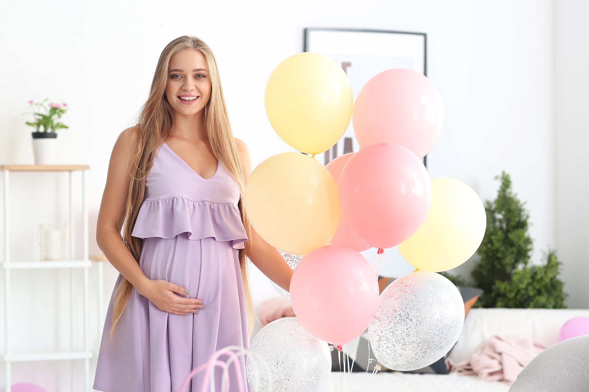 mujer embarazada al lado de globos