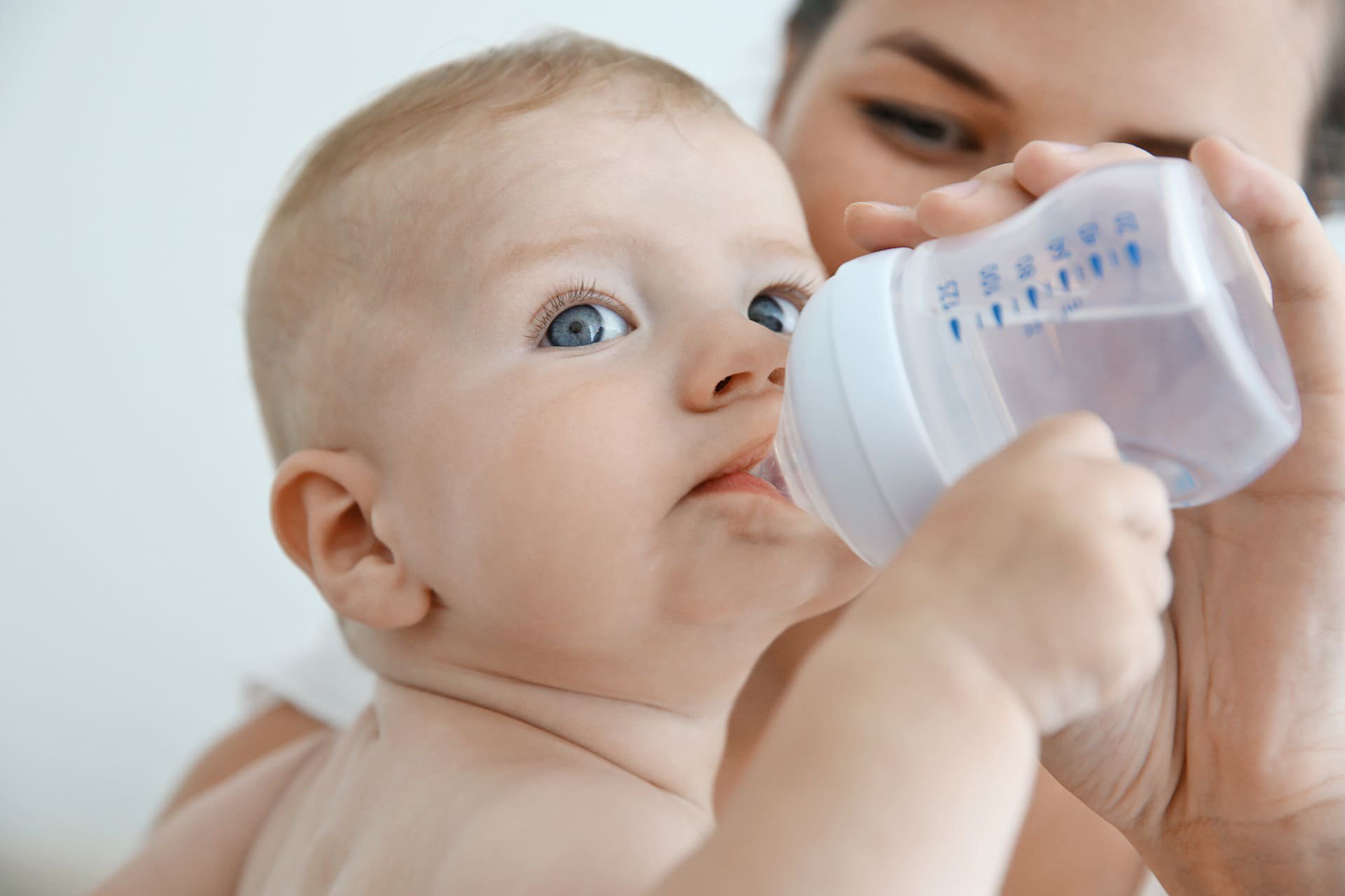 Bebé tomando agua en su tetero.