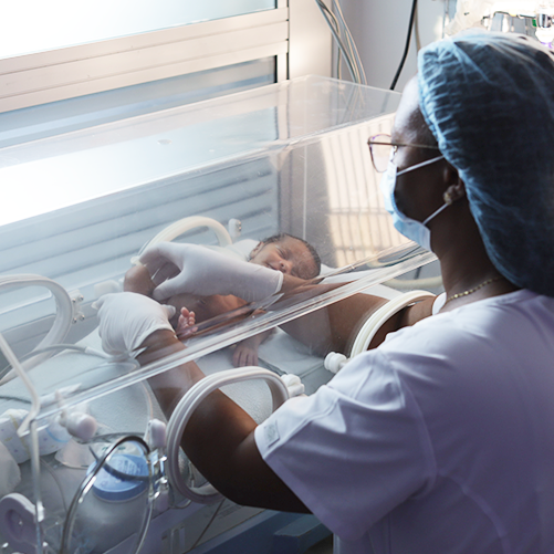 Enfermera cuidando a bebé en incubadora