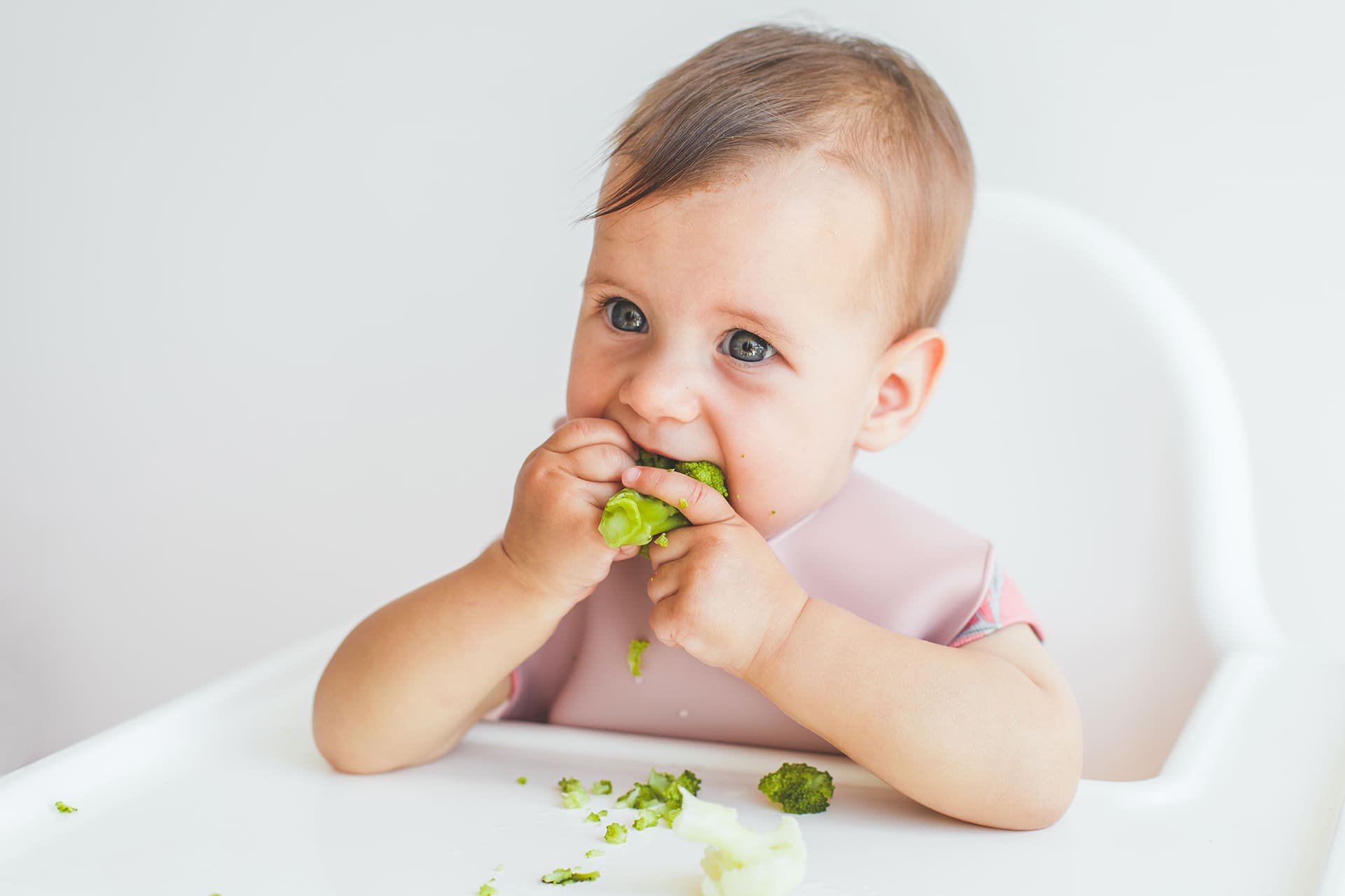 Bebé comiendo con las manos.