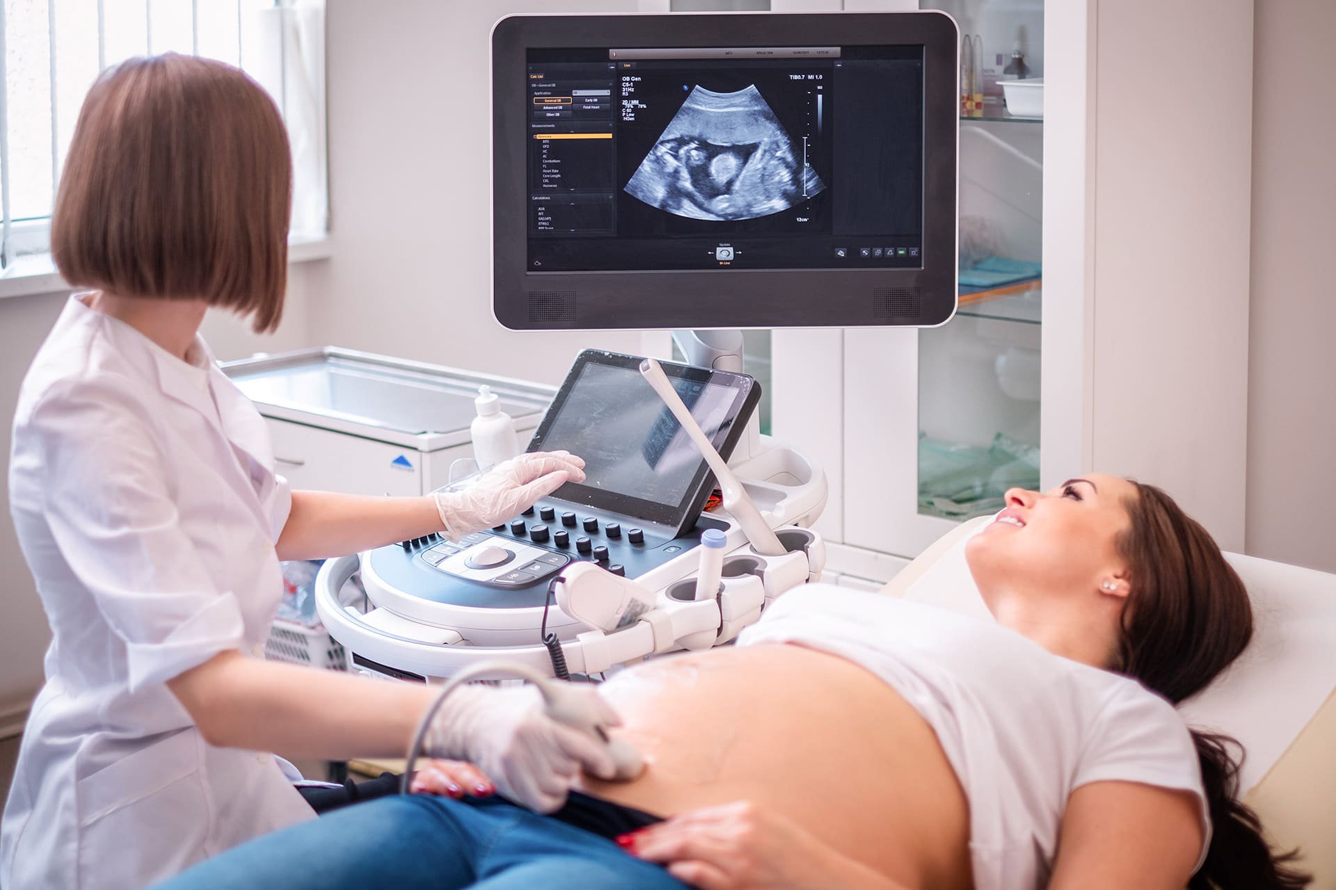 Mujer embarazada viendo su ecografía en control médico.