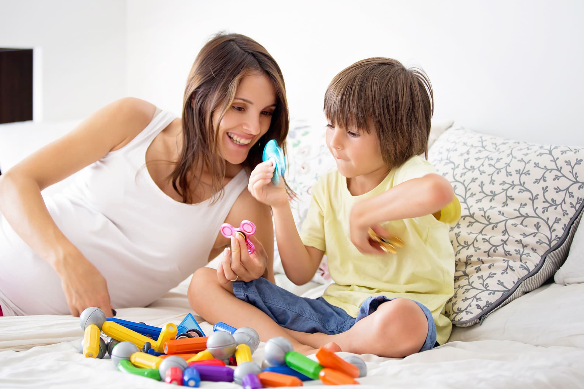 Mamá jugando con su hijo sobre la cama.